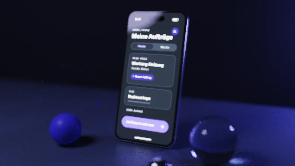 Standbild: ein Smartphone mit der Werk-App auf einem Schreibtisch, der Bildschirm wirft violettes Licht auf den Tisch, im Vordergrund eine Glaskugel mit weichem Schatten